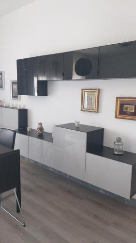 a kitchen with white and black cabinets and a table at La maison de Amelie in Lecce