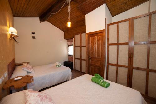 Habitación con 2 camas en una habitación con techos de madera. en Casa Picu La Pantorra, en La Matosa