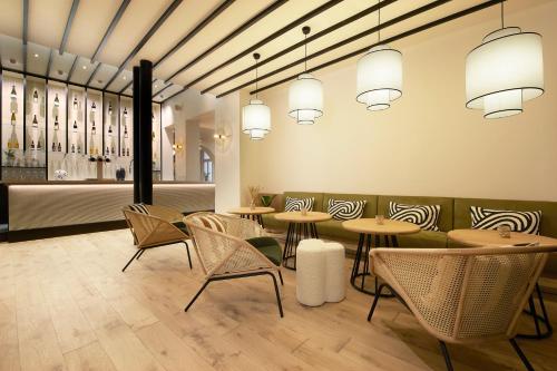 a restaurant with tables and chairs and a bar at Mercure Grand Hôtel Metz Centre Cathédrale in Metz