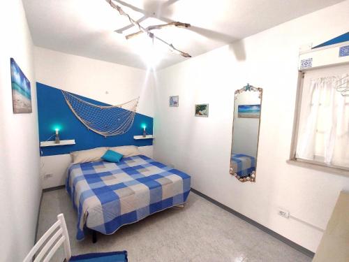 Un dormitorio con una cama azul y blanca y un espejo en The Angels House, en Fossacesia