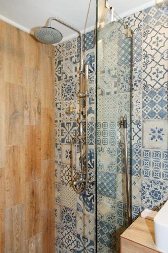 a shower in a bathroom with blue and white tiles at Karali Studios in Nikiti