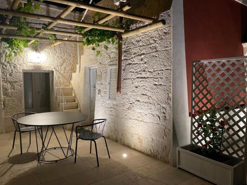 Una mesa y sillas en una habitación con una pared de ladrillos. en Martina Trulli Relais, en Locorotondo