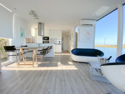 een keuken en een woonkamer met een tafel en een bad bij Homeboat Glamping in Nieuwpoort