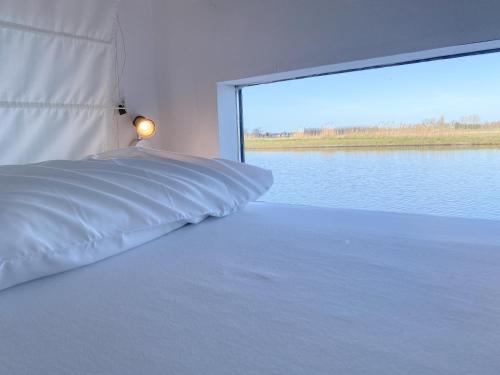 - une chambre avec un lit et une grande fenêtre dans l'établissement Homeboat Glamping, à Nieuport