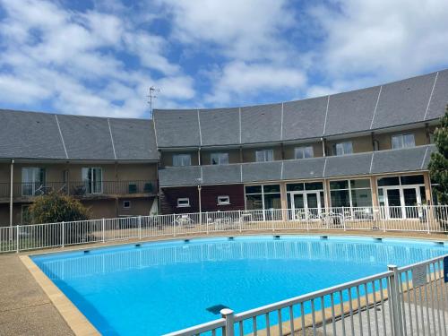 une grande piscine devant un immeuble dans l'établissement Le voilier. Honfleur T2 dans résidence avec piscine, à Équemauville