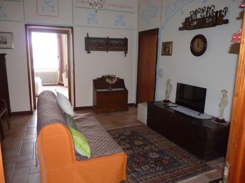 een woonkamer met een bank en een televisie bij Appartamento palazzo del Provveditore vista lago in Desenzano del Garda