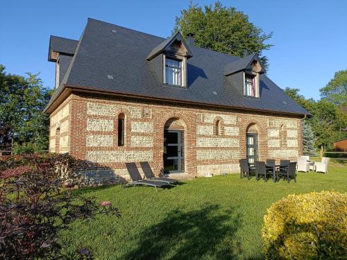 a large brick building with a black roof at DOMAINE DE JANVILLE in Paluel