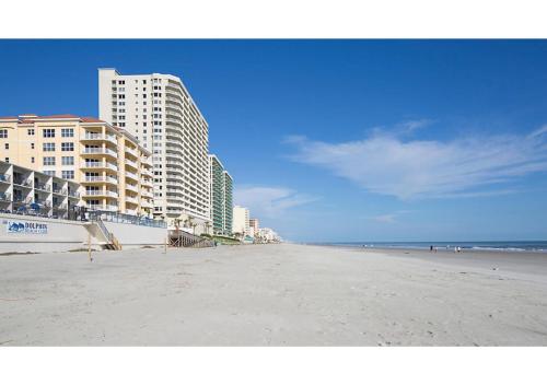 an empty beach with tall buildings and condos at Dolphin Beach Club in Daytona Beach Shores