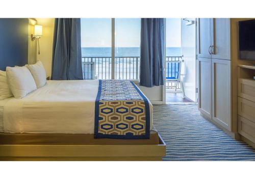 a hotel room with a bed and a view of the ocean at Dolphin Beach Club in Daytona Beach Shores