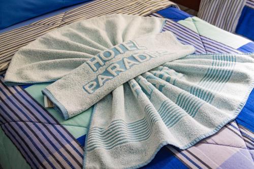 a towel with the words home garden on it on a bed at Paradise Palace Hotel in Aparecida