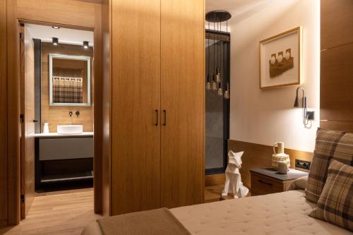a bedroom with a bed and a bathroom with a sink at Cerdanya Mountain Residences in Bellver de Cerdanya 