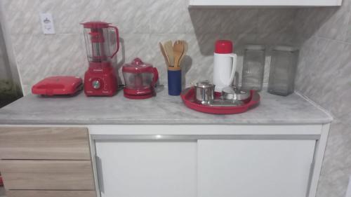 a kitchen counter with a red blender and utensils at Casa no Centro Bananeiras-PB in Bananeiras