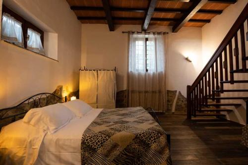 Un dormitorio con una cama en una habitación con escalera. en Rifugio La Foresta, en Montioni Allumiera