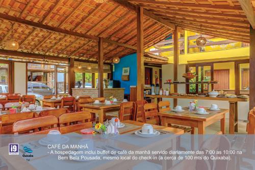 a restaurant with wooden tables and chairs in a building at i9 Quixaba Flat in Itacaré