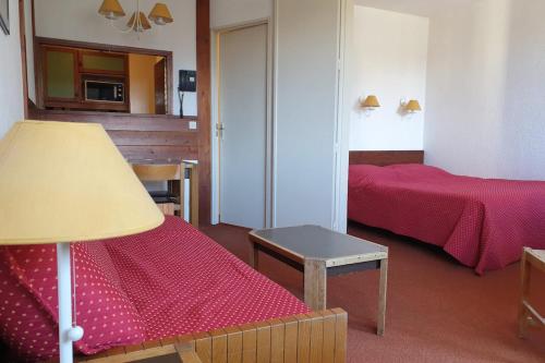 Cette chambre comprend deux lits, une table et une lampe. dans l'établissement 27 m avec BALCON-VUE Mont-Blanc-HYPERCENTRE, à Chamonix-Mont-Blanc