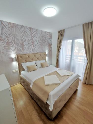 een slaapkamer met een groot bed in een kamer bij Elena in Herceg-Novi