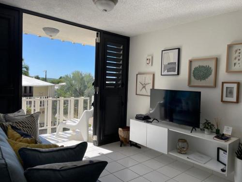 a living room with a tv and a couch at Boquerón Beach Apartment.- Guarionex 207 in Cabo Rojo