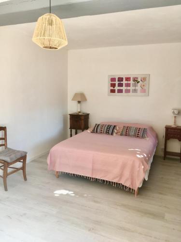 une chambre avec un lit, une chaise et une lampe dans l'établissement Gîte plein cœur de Sologne, à Marcilly-en-Gault