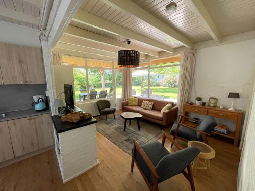 salon z kanapą i telewizorem w obiekcie Tofino, een comfortabel vakantiehuis naast een bos en zwemmeer w mieście Gasselte