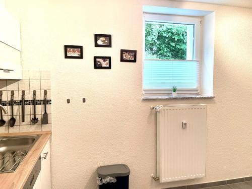 una cucina con frigorifero e quadri appesi al muro di Komfort Ferienwohnung Vakantiewoning nähe Bosenbergklinik a Sankt Wendel