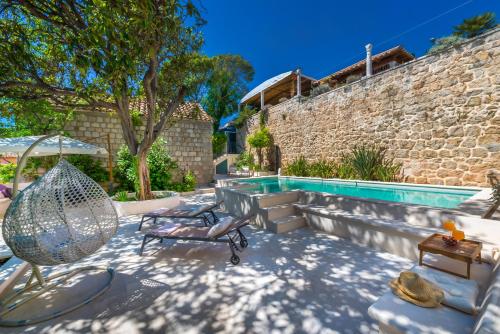 eine Terrasse mit einer Hängematte und einem Pool in der Unterkunft Villa Flores Garden in Dubrovnik
