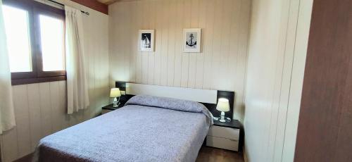 a small bedroom with a bed and two lamps at Conil, 5min centro, playas in Conil de la Frontera