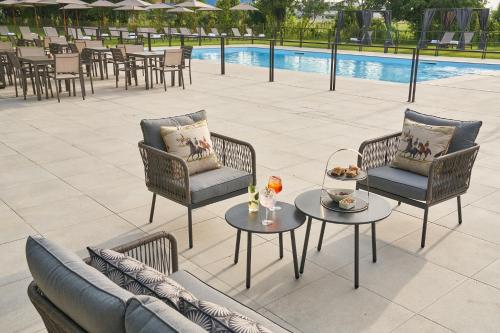 a patio with chairs and tables next to a pool at Alle Siepi in Reggio Emilia