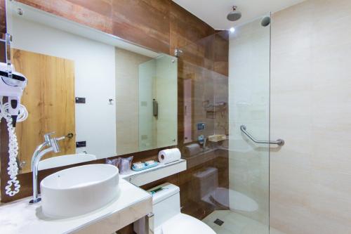 a bathroom with a toilet and a glass shower at Grand Hotel Leon Marino Galapagos in Puerto Ayora