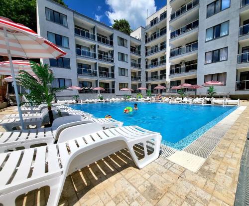 una piscina con tumbonas y un hotel en Dilov Apartments in Yalta Golden Sands en Golden Sands