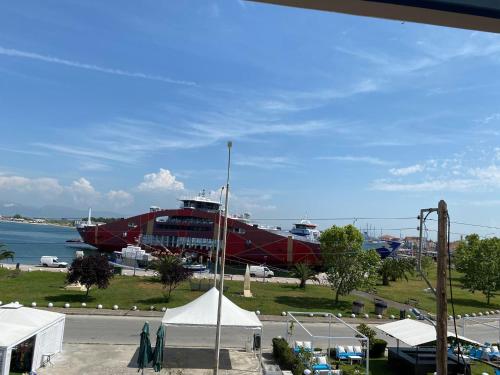 a large red boat on the grass near the water at Sea View in Keramotí
