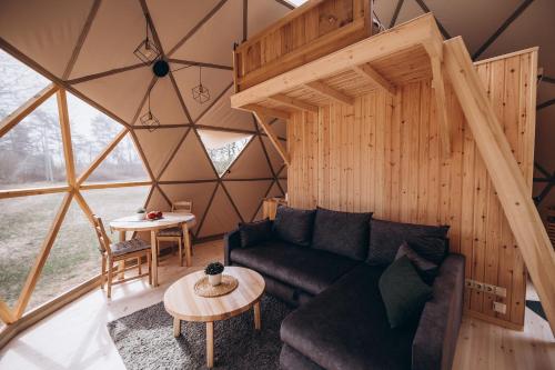 a living room in a dome with a couch and a table at VasaRojaus Kupolai in Birštonas