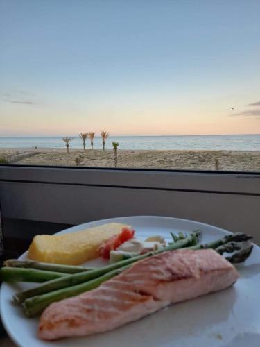 a plate of food with a view of the beach at T3 avec magnifique vue mer in Le Barcarès