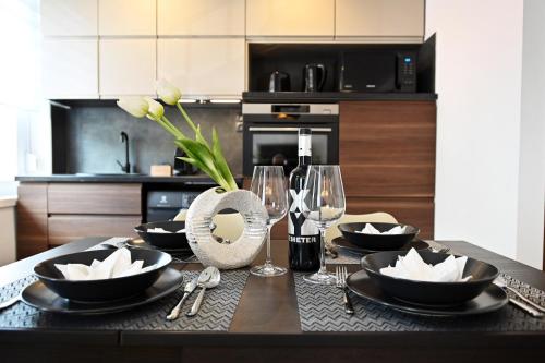 uma cozinha com uma mesa com pratos e copos de vinho em ZÓRA APARTMAN em Eger