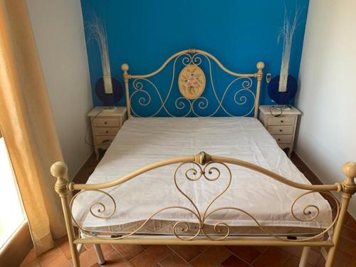 1 cama en un dormitorio con una pared azul en Residence via del Colle en Viddalba