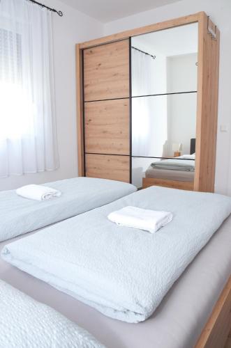 a bedroom with two beds and a mirror at Apartman RIO in Jajce