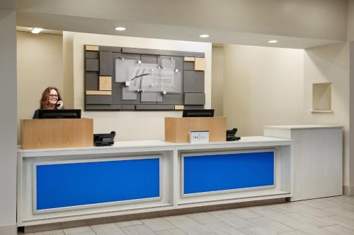 a woman standing behind a counter in a lobby at Holiday Inn Express & Suites Bonifay by IHG in Bonifay