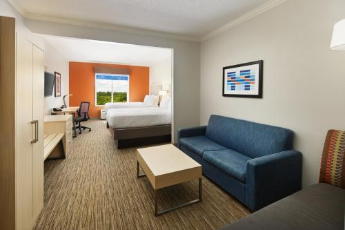 a hotel room with a bed and a blue couch at Holiday Inn Express & Suites Bonifay, an IHG Hotel in Bonifay