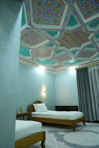 a room with two beds and a coffered ceiling at Shaherezada Boutique Hotel in Khiva