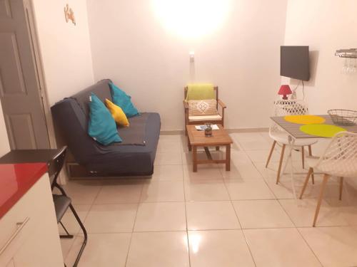 a living room with a couch and a table at CHEZ COCO appartement BALISIER in Rivière-Salée