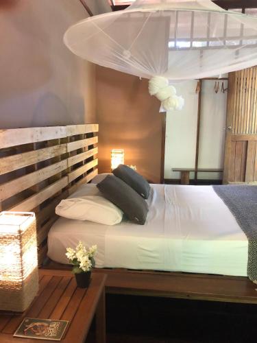 a bed with pillows on it with a table at Hotel Luz de Luna in Santa Teresa Beach