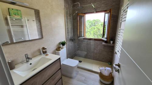a bathroom with a sink and a toilet and a window at Apartamento Mirador Valdeiglesias in Pelayos de la Presa