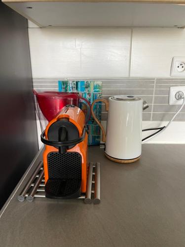 un mixeur orange posé sur un comptoir de cuisine dans l'établissement Appartement T3 sur l'esplanade de l'europe, à Montpellier