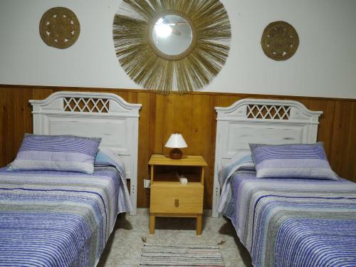 a bedroom with two beds and a mirror on the wall at Mary's Home in Moya