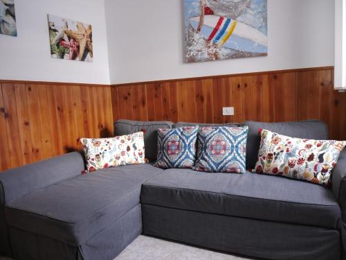 a gray couch in a room with wooden walls at Mary's Home in Moya