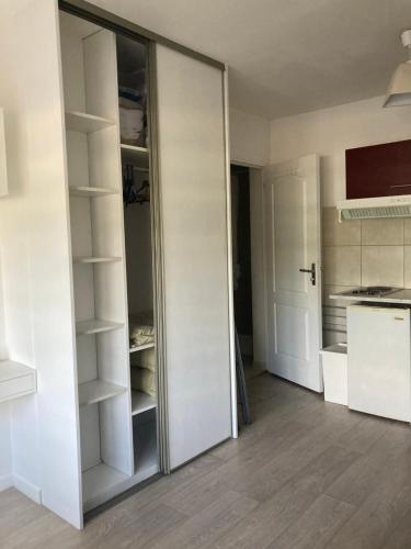 - une porte coulissante en verre dans une chambre avec cuisine dans l'établissement Studio tout équipé au calme, à Cappelle-la-Grande