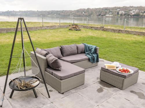 a couch sitting on top of a patio at Bwthyn Siliwen Old Bath House in Bangor