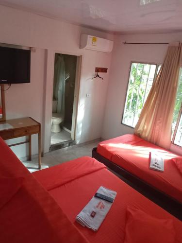 a room with two beds and a television and a bathroom at Hotel Panorama Neiva in Neiva