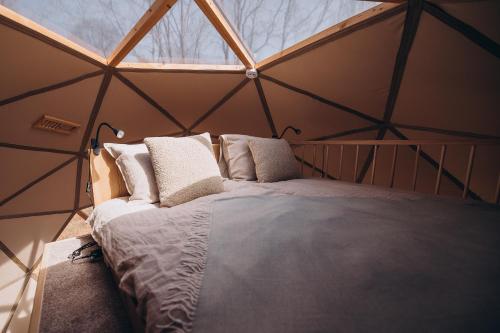a bedroom with a bed in a tent at VasaRojaus Kupolai in Birštonas