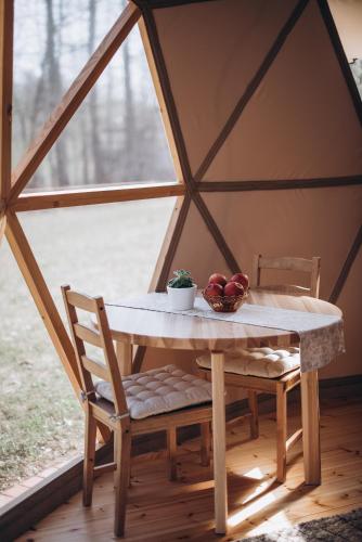 a table in a yurt with a bowl of fruit on it at VasaRojaus Kupolai in Birštonas
