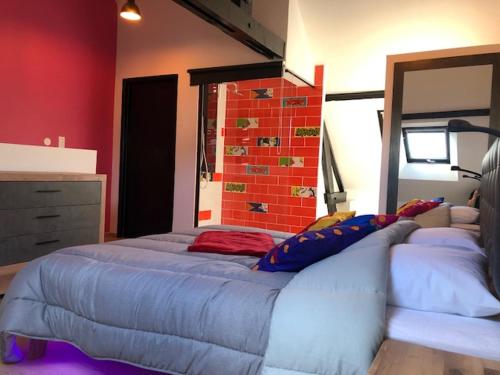 een slaapkamer met een groot bed en een bakstenen muur bij Maison avec garage Pop' Appart' in Laon